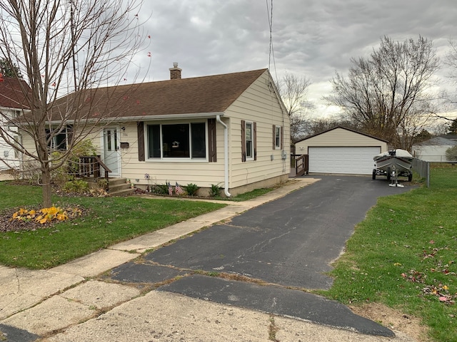 view of front of property with a front yard, an outdoor structure, and a garage