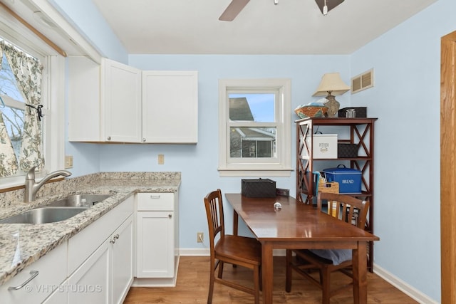 dining space featuring ceiling fan, light hardwood / wood-style floors, and sink