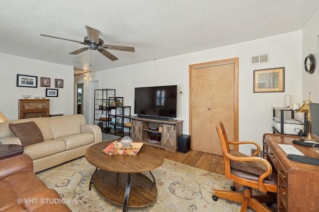 living room featuring light hardwood / wood-style floors and ceiling fan