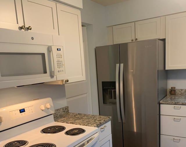 kitchen featuring white cabinetry, stone countertops, and white appliances