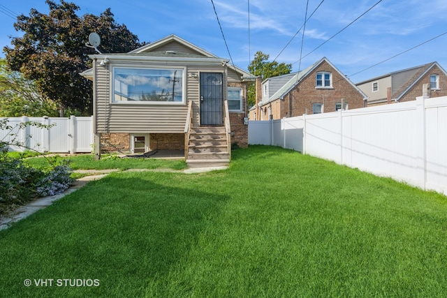 rear view of property with a yard