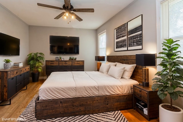 bedroom with ceiling fan, light wood-type flooring, and ornamental molding