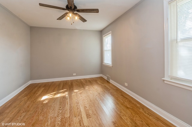 spare room with light wood-type flooring, ceiling fan, and crown molding