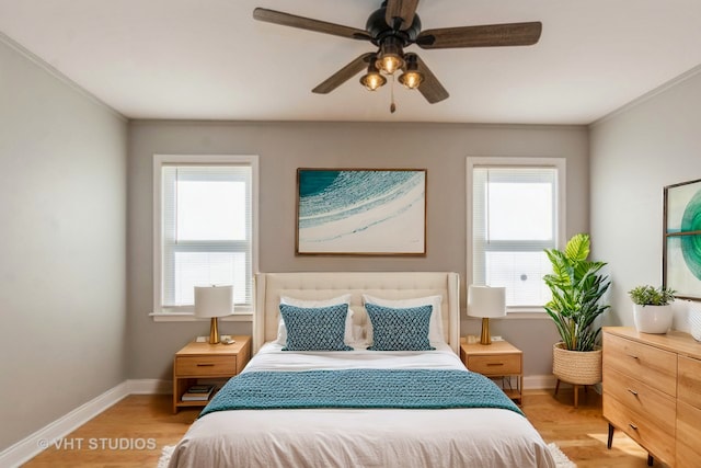 bedroom featuring light hardwood / wood-style flooring, multiple windows, ornamental molding, and ceiling fan