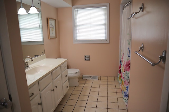 bathroom with toilet, vanity, tile patterned floors, and plenty of natural light