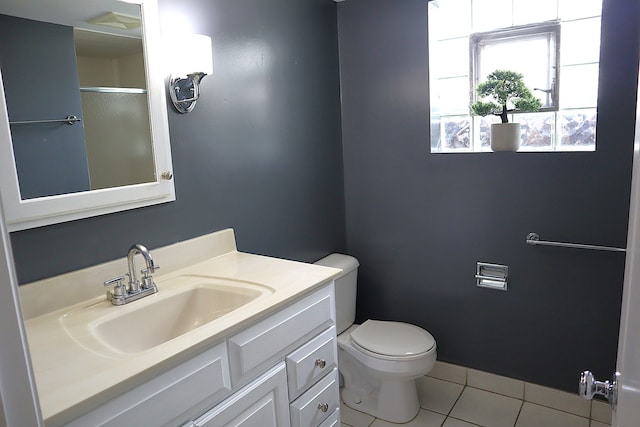 bathroom featuring tile patterned floors, vanity, toilet, and a shower with shower door