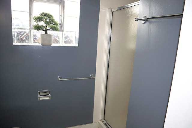 bathroom with a shower with door