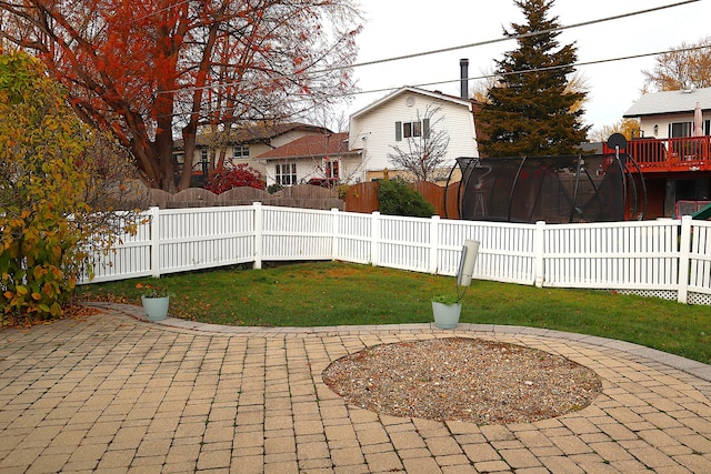 view of yard featuring a trampoline and a patio area