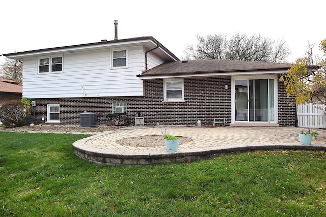 back of house with central AC unit, a yard, and a patio