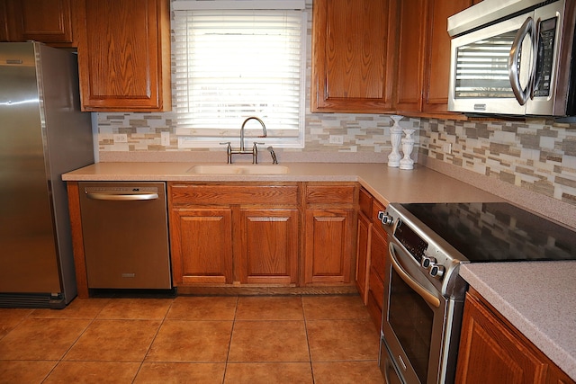 kitchen featuring decorative backsplash, light tile patterned floors, sink, and appliances with stainless steel finishes