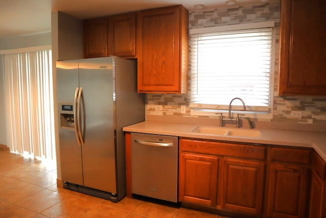 kitchen with light tile patterned floors, stainless steel appliances, tasteful backsplash, and sink