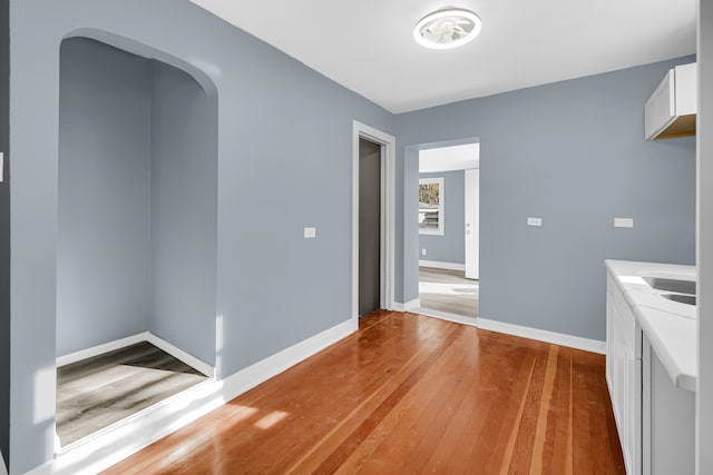 unfurnished dining area with wood-type flooring and sink