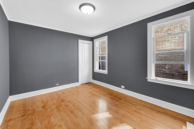 spare room with wood-type flooring and ornamental molding