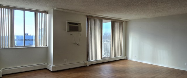 empty room with a wealth of natural light, hardwood / wood-style floors, and a wall mounted air conditioner