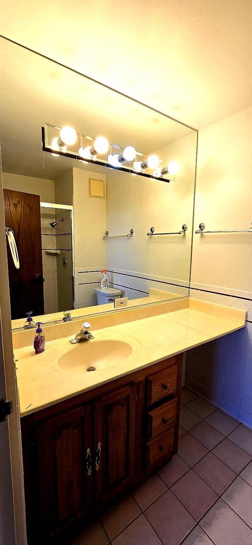 bathroom featuring vanity, a shower stall, and tile patterned floors