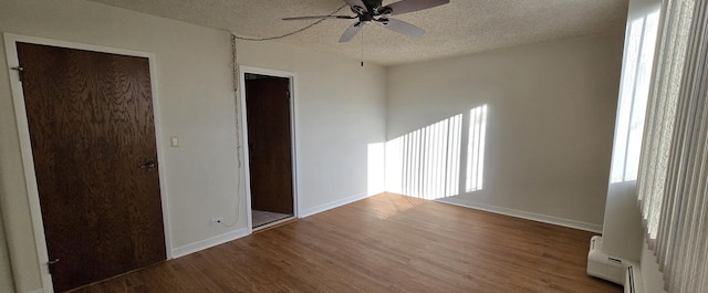 unfurnished room featuring a textured ceiling, ceiling fan, baseboard heating, and hardwood / wood-style floors