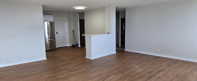 spare room with a textured ceiling and dark hardwood / wood-style flooring