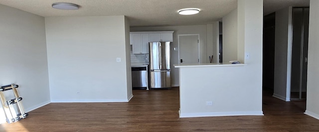 empty room with dark hardwood / wood-style flooring and a textured ceiling