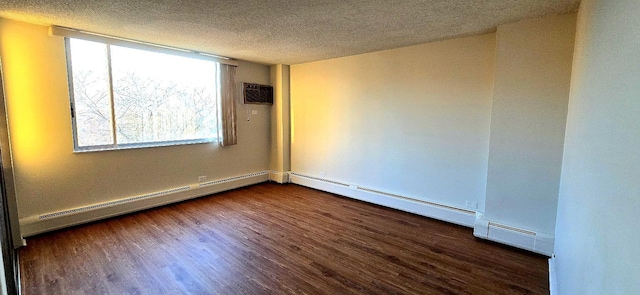 spare room featuring a textured ceiling, dark wood-type flooring, baseboard heating, and plenty of natural light