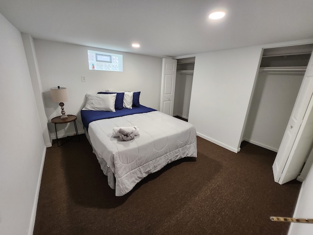 bedroom with multiple closets and dark colored carpet