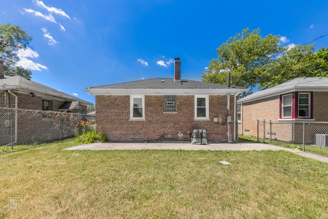 back of property with a lawn and a patio area