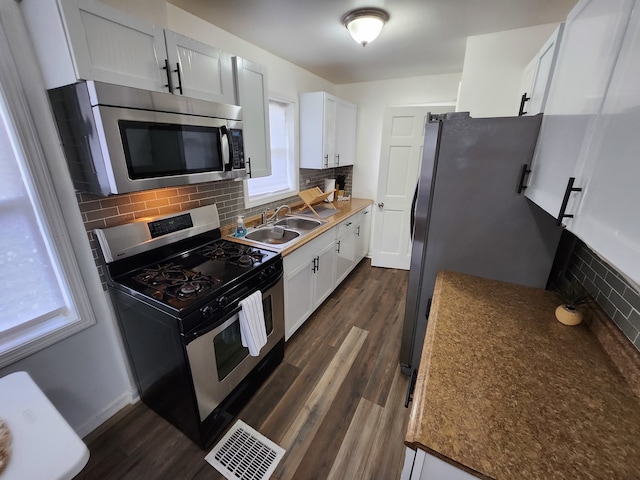 kitchen with white cabinets, decorative backsplash, stainless steel appliances, and dark wood-type flooring