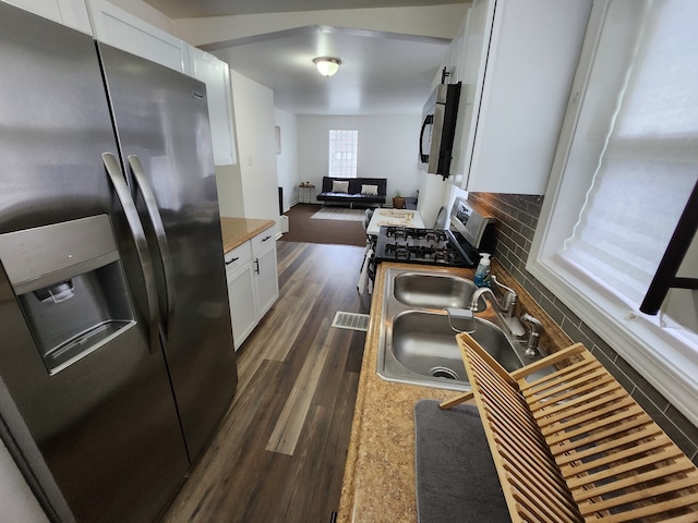 kitchen with decorative backsplash, appliances with stainless steel finishes, dark hardwood / wood-style flooring, sink, and white cabinets