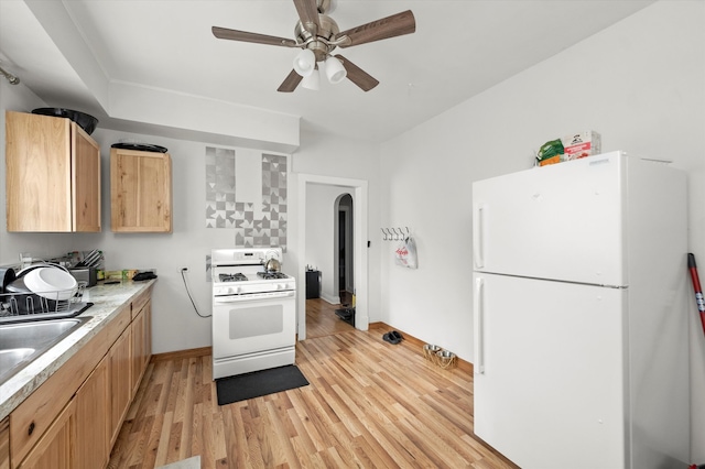 kitchen featuring white appliances, sink, ceiling fan, light brown cabinetry, and light hardwood / wood-style floors