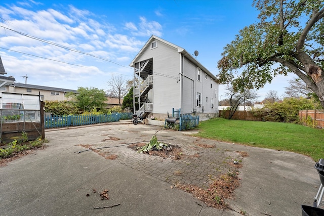 back of property with a yard and a patio