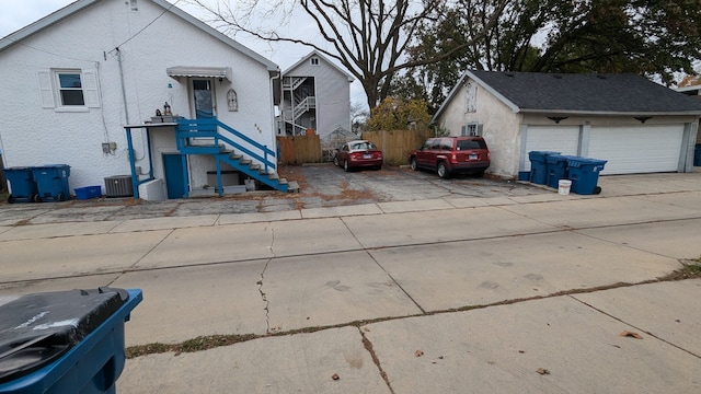 view of front of home featuring an outbuilding, a garage, and central AC unit