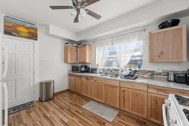 kitchen featuring light wood-type flooring, white range, ceiling fan, and sink