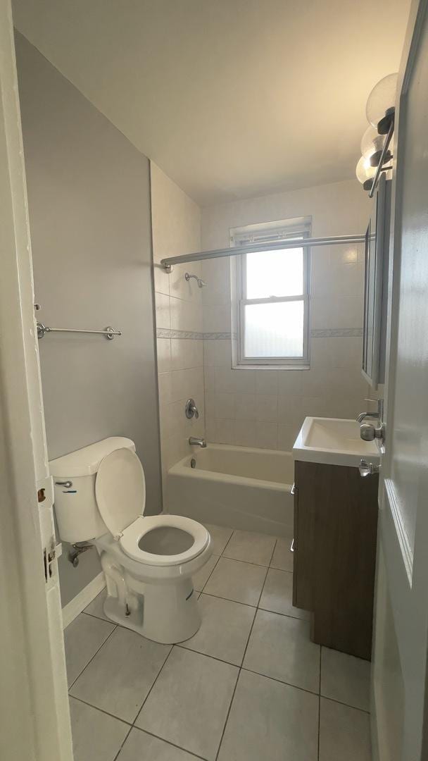 full bathroom featuring vanity, tiled shower / bath combo, tile patterned floors, and toilet