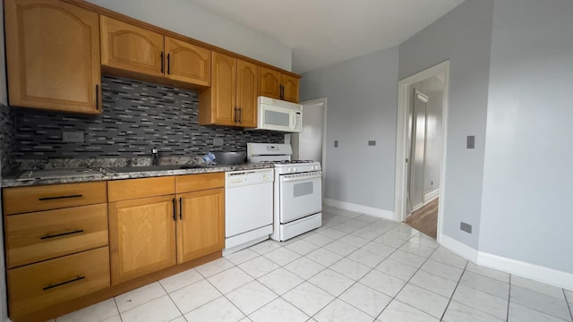 kitchen featuring sink, white appliances, light tile patterned floors, and backsplash