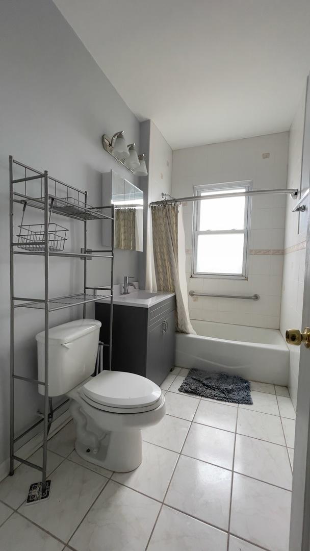 full bathroom featuring vanity, shower / tub combo, and toilet