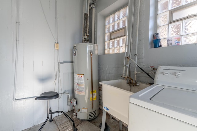 clothes washing area with sink, gas water heater, and washer / dryer