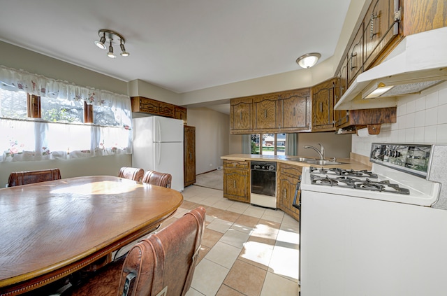 kitchen with sink, light tile patterned floors, a healthy amount of sunlight, and white appliances