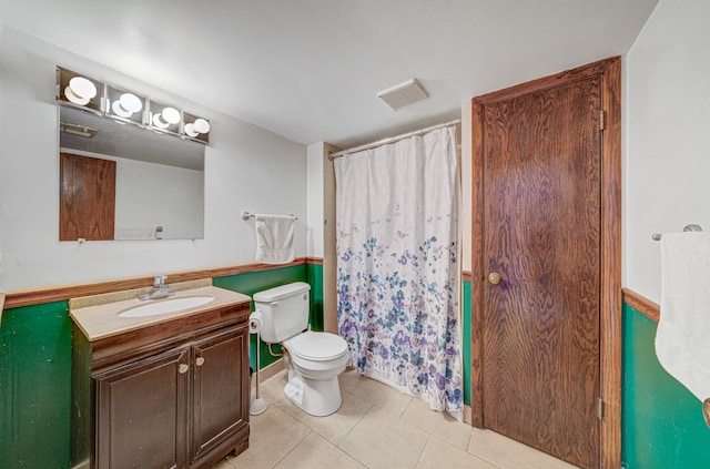 bathroom featuring tile patterned flooring, vanity, and toilet