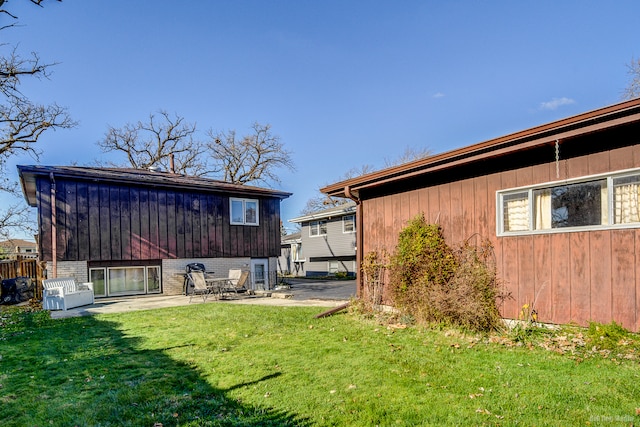 rear view of property featuring a patio area and a lawn