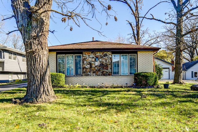 view of front of house with a garage, an outdoor structure, and a front yard