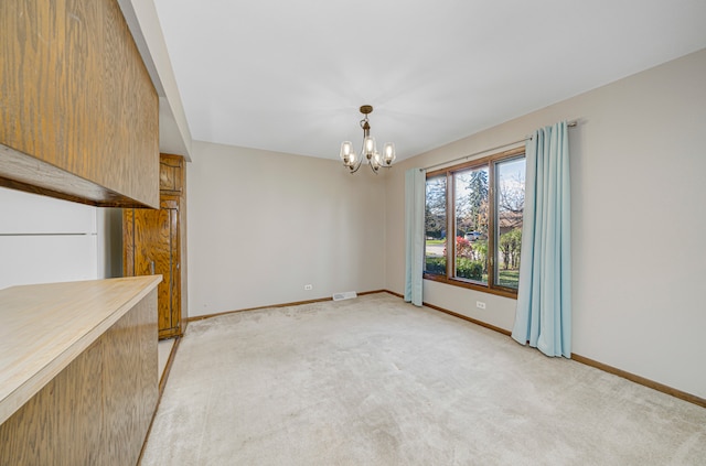 unfurnished dining area featuring light colored carpet and a chandelier