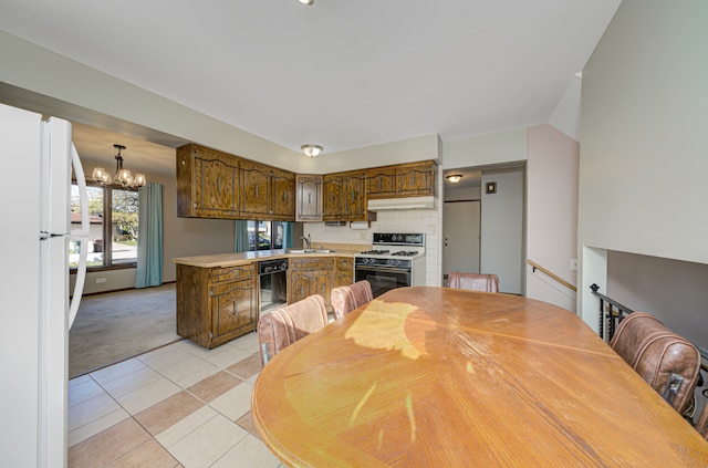 kitchen featuring sink, light tile patterned floors, white appliances, and a notable chandelier