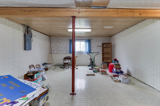 basement with wood ceiling, electric panel, and brick wall