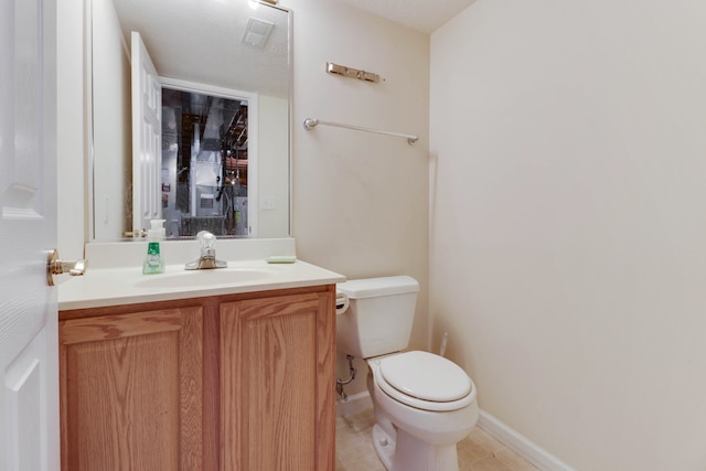 bathroom featuring tile patterned floors, vanity, a textured ceiling, and toilet