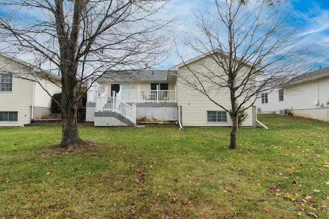 rear view of house featuring a lawn and a wooden deck