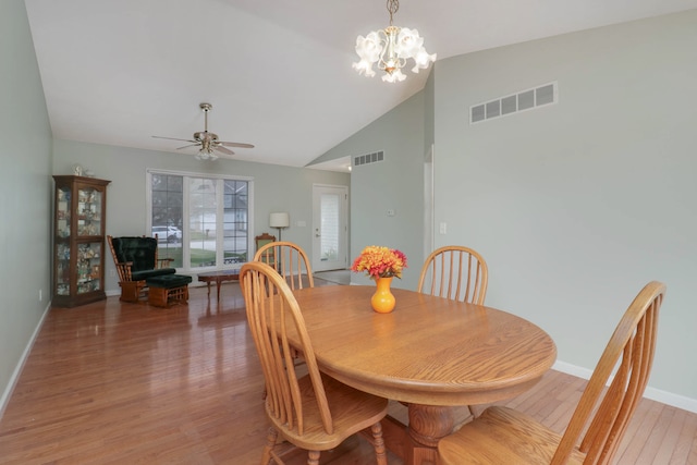 dining room featuring high vaulted ceiling, ceiling fan with notable chandelier, and light wood-type flooring