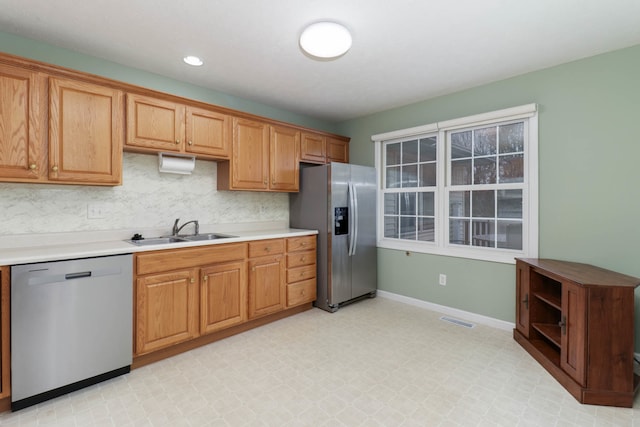 kitchen featuring backsplash, stainless steel appliances, and sink