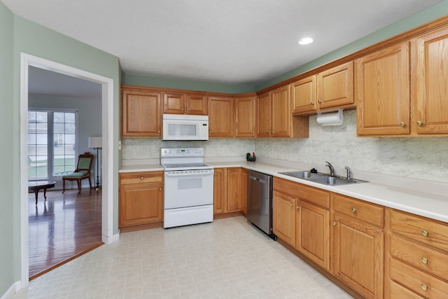 kitchen featuring white appliances, tasteful backsplash, light hardwood / wood-style flooring, and sink