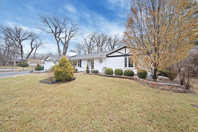 view of front of home with a front yard and fence