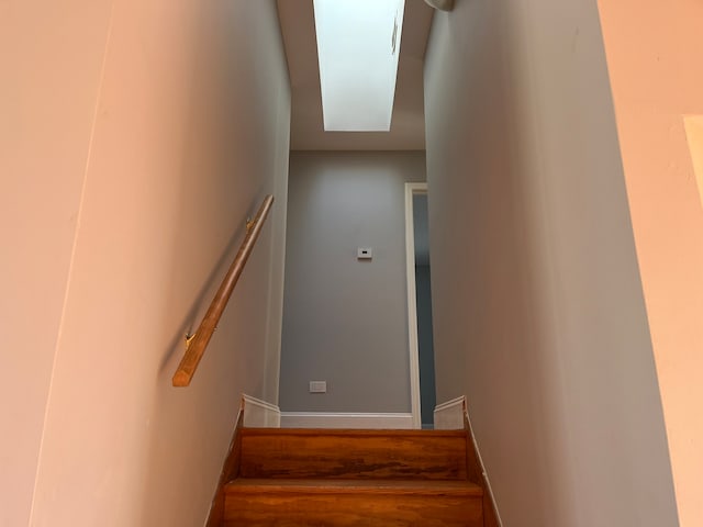 stairs featuring hardwood / wood-style flooring and a skylight