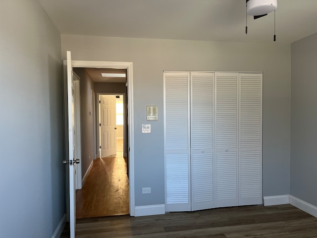 unfurnished bedroom featuring dark wood-type flooring and a closet